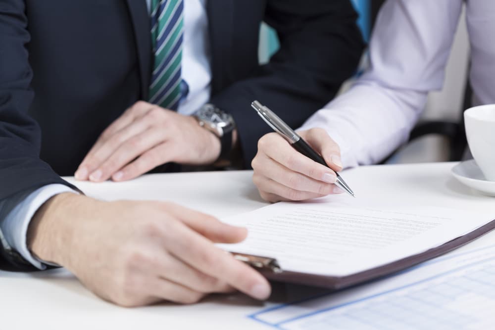 עורך דין עוזר ללקוחה לחתום על מסמך של תביעות ביטוח לאומי